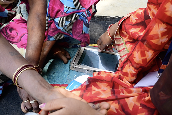 Usha enters details into her tablet while examining a patient in Uttar Pradesh, India. 
