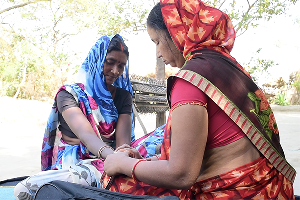 Usha, a Basic Care Provider, examines a patient in Usha Pradesh, India.