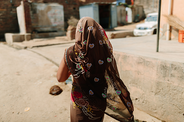 An Indian woman walks with her back to the camera
