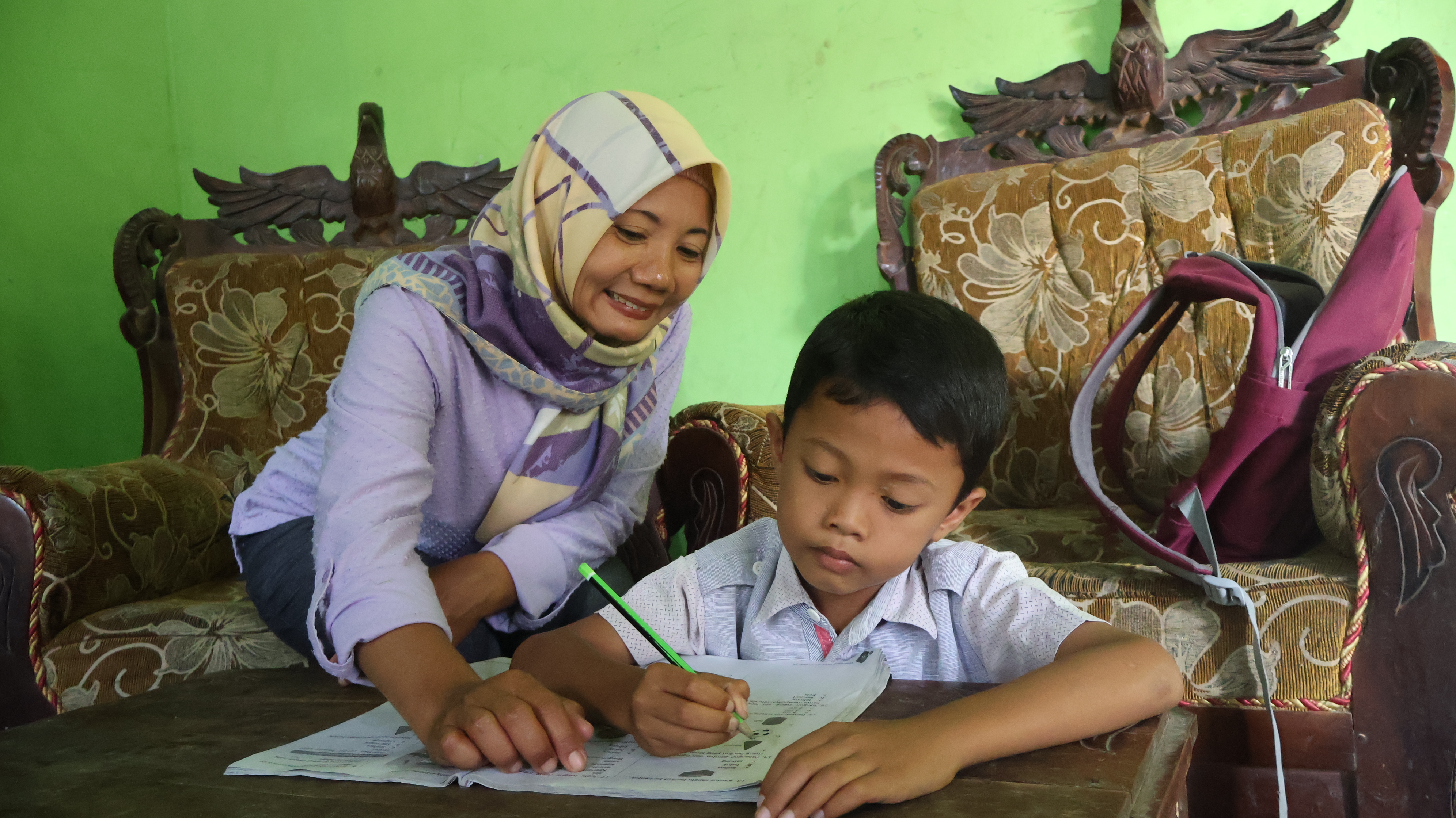 Supanti helps her youngest son with his school homework
