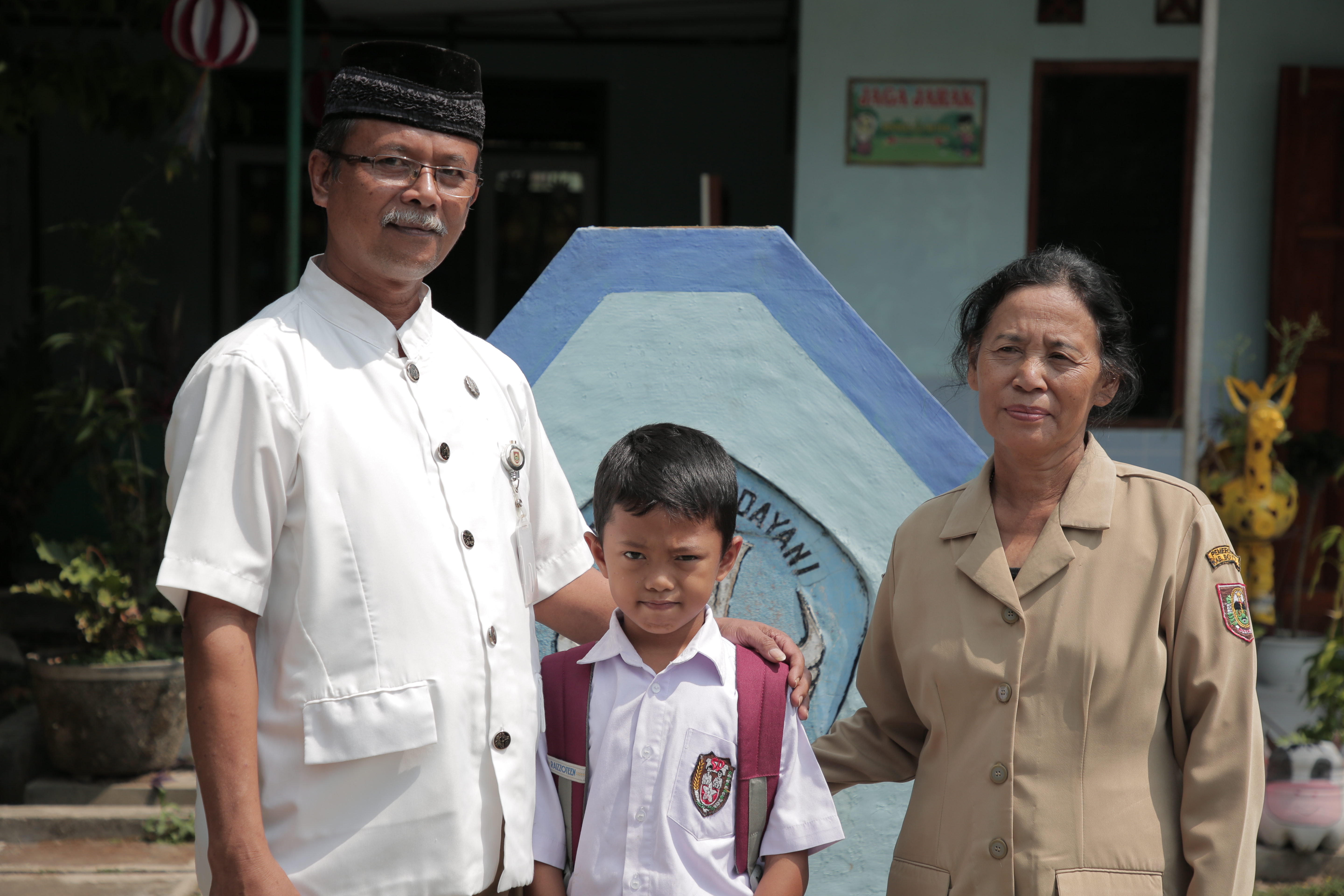 Supanti's child with his teacher and school principal